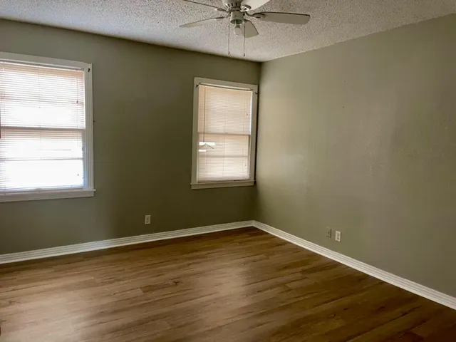 a view of a room with wooden floor and windows