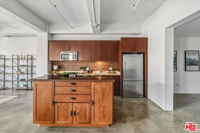 a kitchen with stainless steel appliances granite countertop a refrigerator and a stove