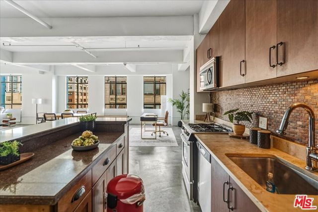 a kitchen with stainless steel appliances granite countertop a sink stove and cabinets