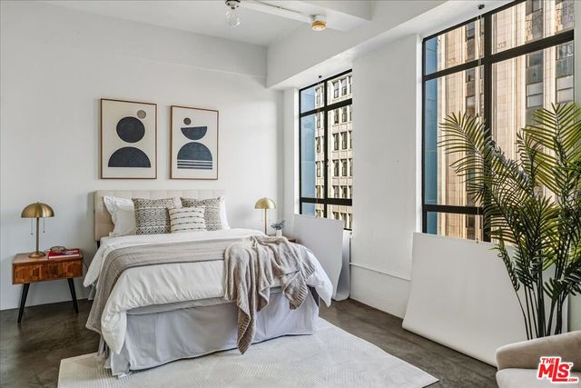 a bedroom with a bed and a large window with outer view