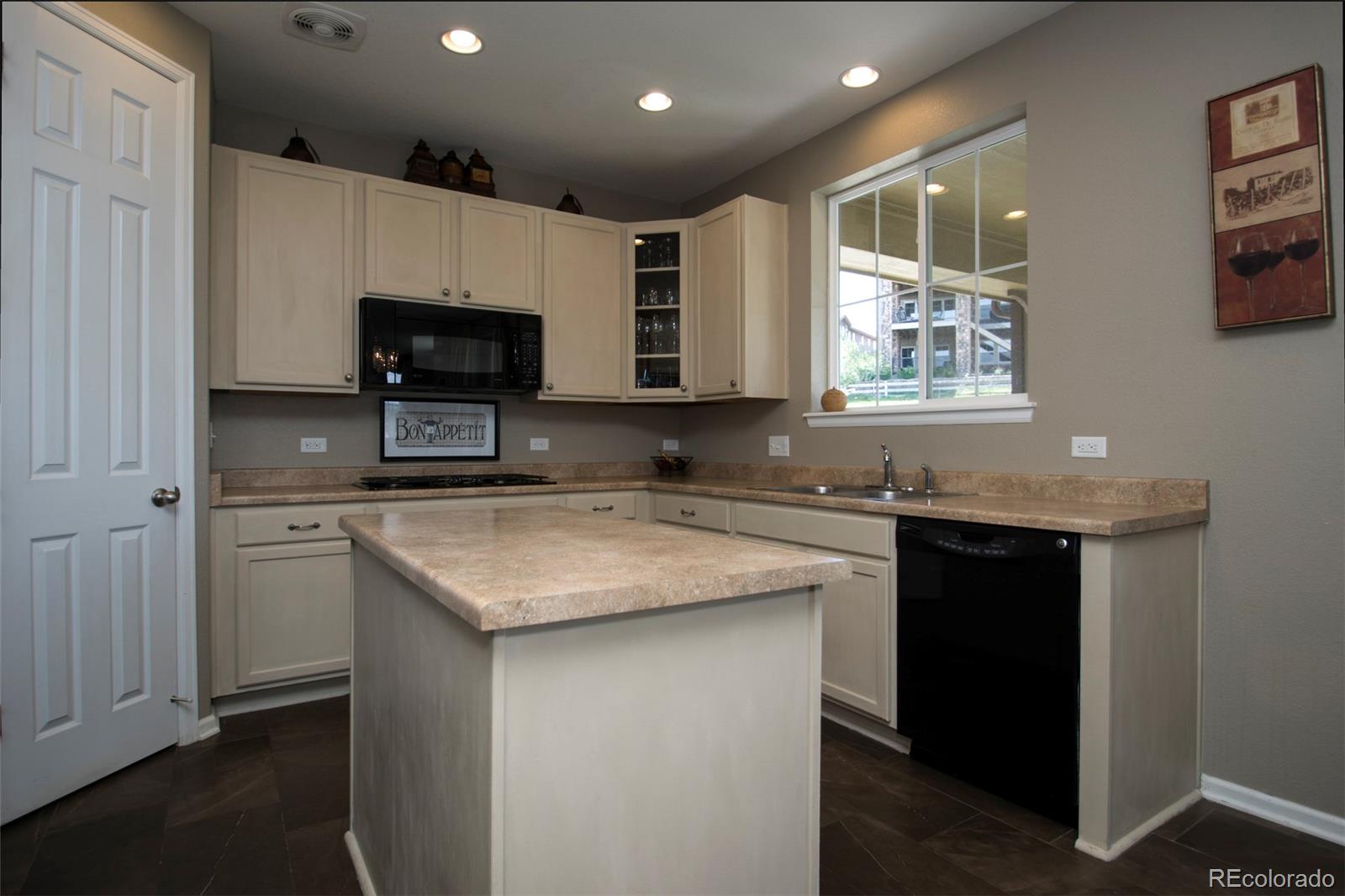10459 Meadowleaf Way Highlands Ranch, CO 80126 - Photo 7 of 33 a kitchen with stainless steel appliances granite countertop a sink stove and microwave