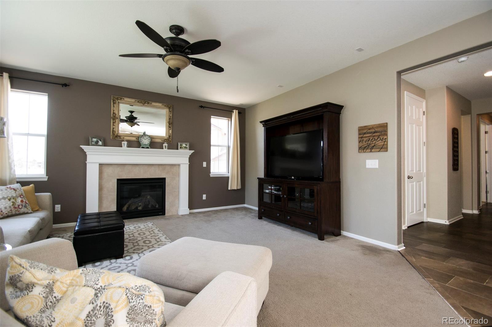 10459 Meadowleaf Way Highlands Ranch, CO 80126 - Photo 9 of 33 a living room with furniture a flat screen tv and a fireplace