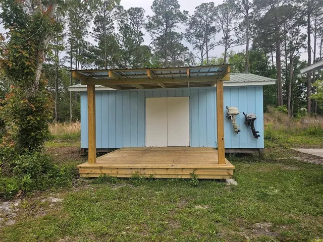 a view of backyard with wooden fence and trees
