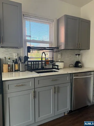 a kitchen with stainless steel appliances granite countertop white cabinets sink and a granite counter top