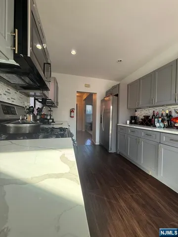 a kitchen with stainless steel appliances granite countertop a sink a stove and a refrigerator