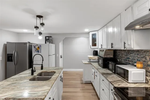 a kitchen with stainless steel appliances granite countertop a sink stove and refrigerator