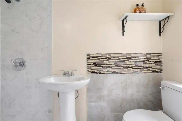 a bathroom with a toilet a sink a vanity and mirror