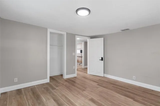 a view of an empty room with wooden floor