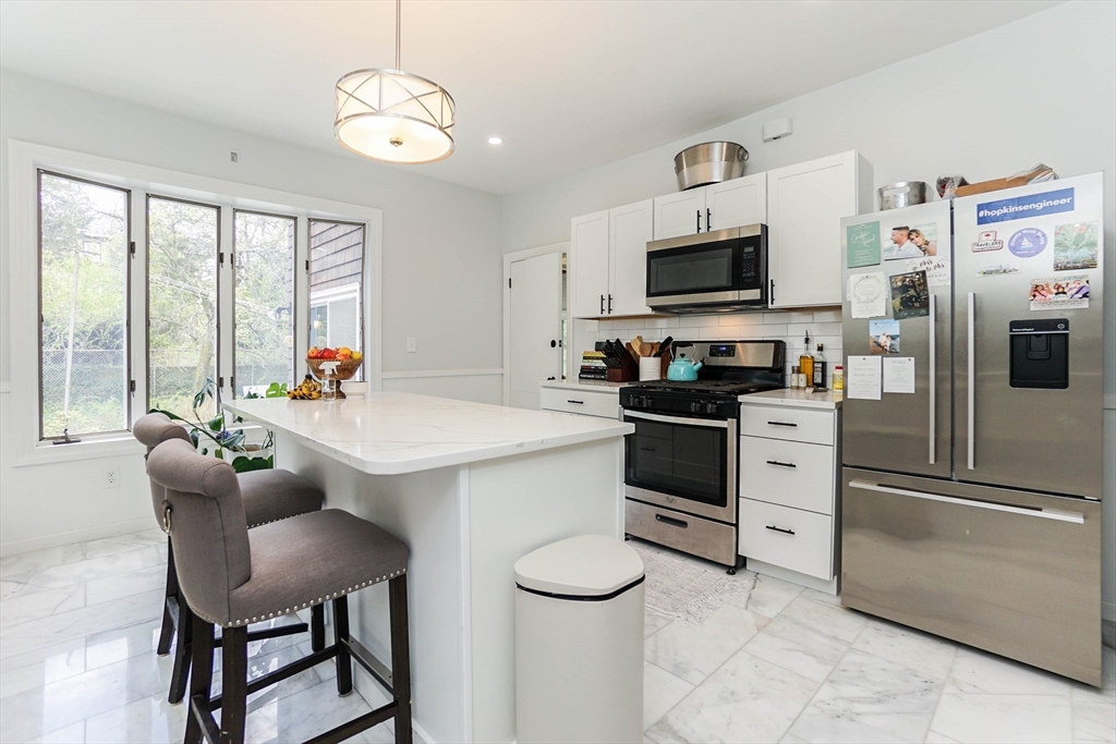 a kitchen with stainless steel appliances a stove a refrigerator and a dining table