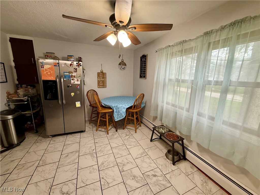 8195 Nichols Road Windham, OH 44288 - Photo 14 of 41 Dining room featuring a ceiling fan, marble finish floor, and baseboard heating