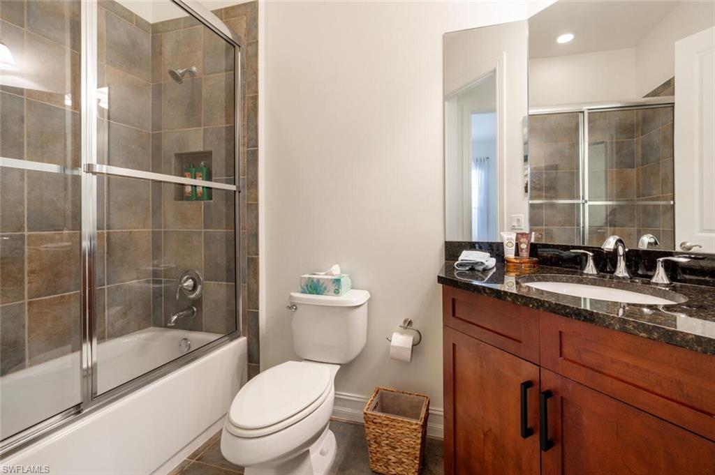 7563 Moorgate Point Way Naples, FL 34113 - Photo 19 of 50 a bathroom with a granite countertop sink a toilet and shower