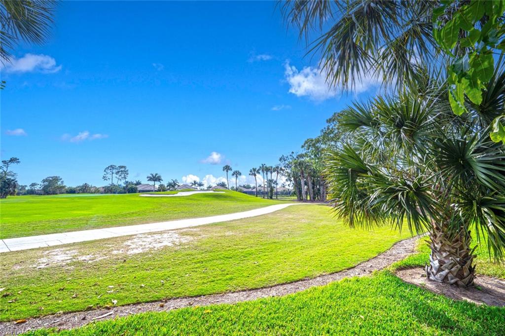 7563 Moorgate Point Way Naples, FL 34113 - Photo 25 of 50 a view of a swimming pool and green space