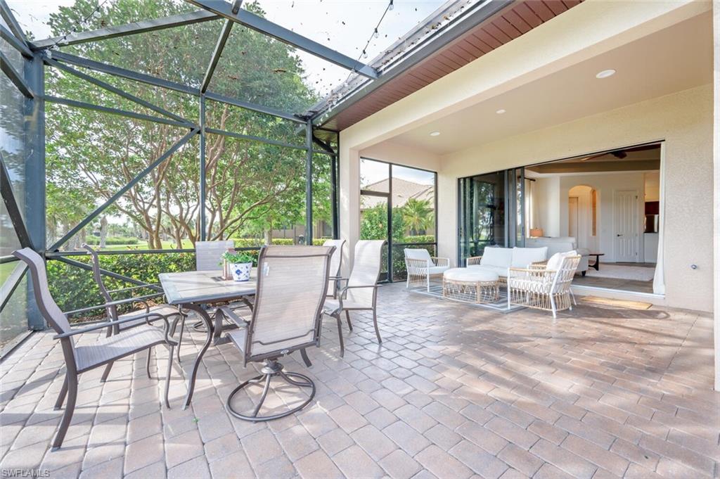 7563 Moorgate Point Way Naples, FL 34113 - Photo 6 of 50 a view of a patio with a dining table and chairs