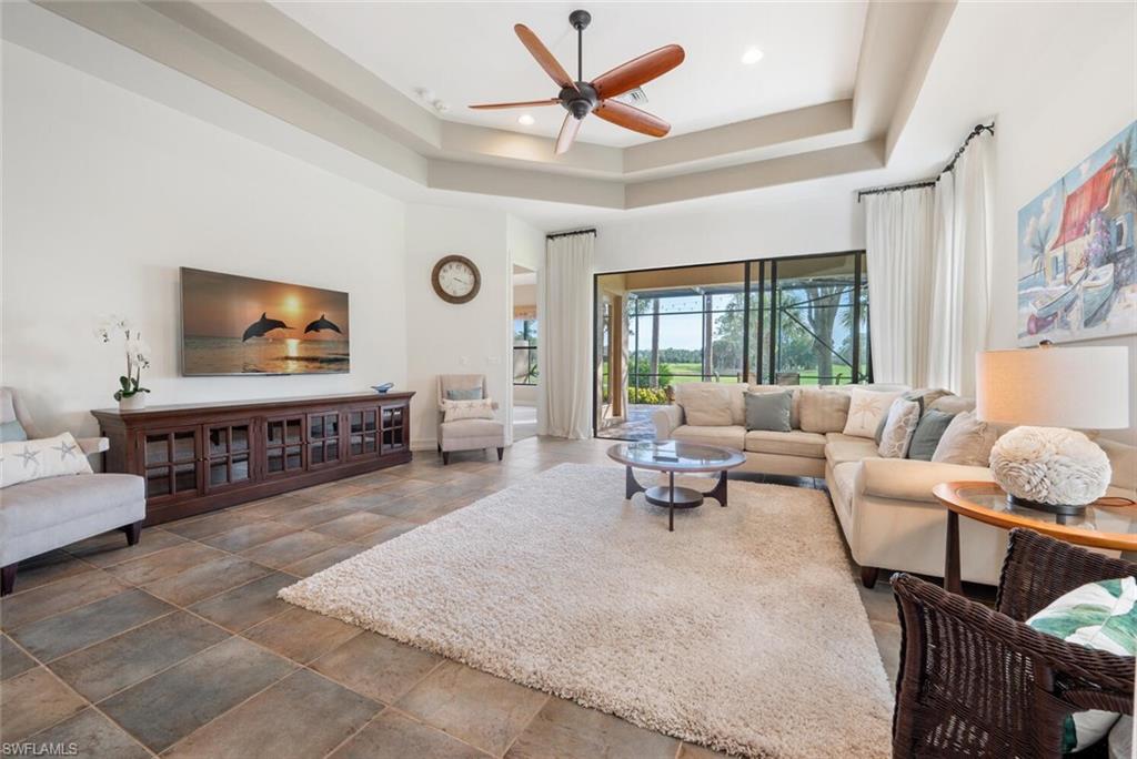 7563 Moorgate Point Way Naples, FL 34113 - Photo 7 of 50 a living room with furniture a large window and a flat screen tv