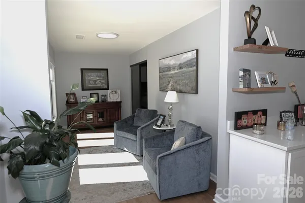 a living room with furniture and a potted plant on a dresser