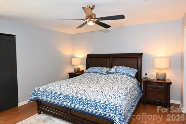 a bedroom with a bed and a lamp on the dresser