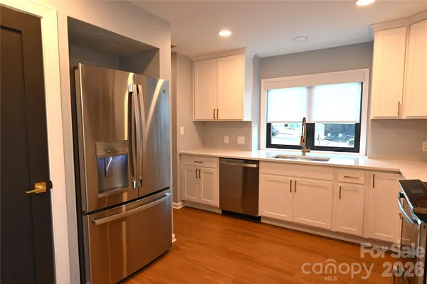 a kitchen with stainless steel appliances granite countertop a refrigerator and a sink