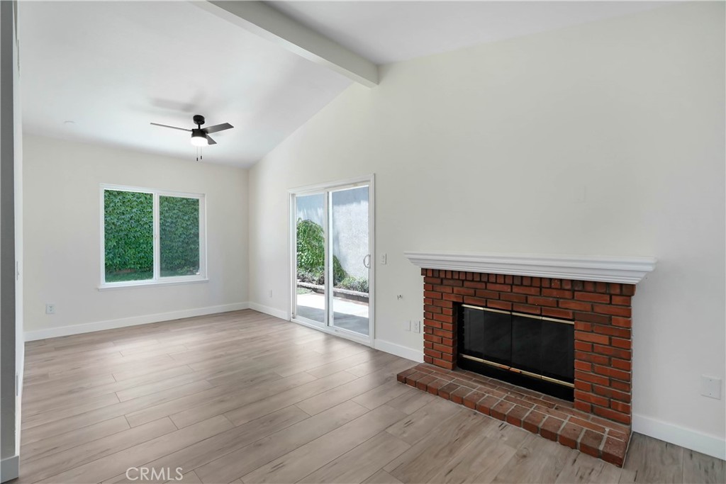 11629 Mt Jefferson Drive Rancho Cucamonga, CA 91737 - Photo 5 of 17 an empty room with wooden floor a fireplace and windows