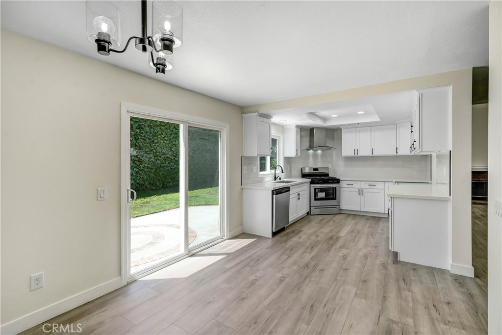 11629 Mt Jefferson Drive Rancho Cucamonga, CA 91737 - Photo 8 of 17 a kitchen with stainless steel appliances a sink and wooden floor