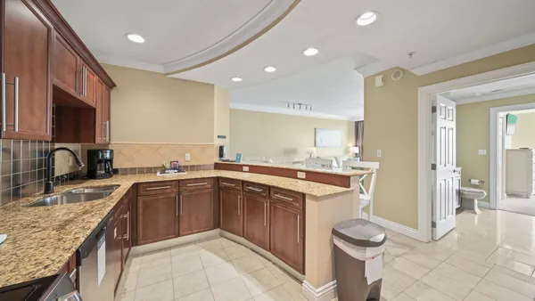 a kitchen with a sink and a stove top oven with wooden floor