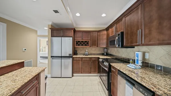 a kitchen with a sink a refrigerator and a stove top oven