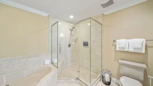a bathroom with a granite countertop double vanity sink mirror double shower and a mirror