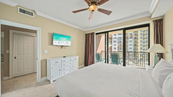 a bedroom with a large bed a chandelier and a window