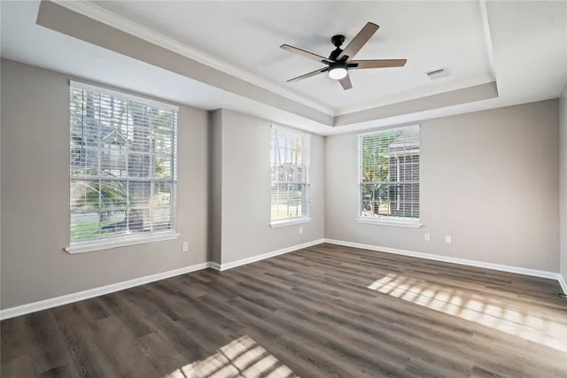 a view of empty room with wooden floor and fan
