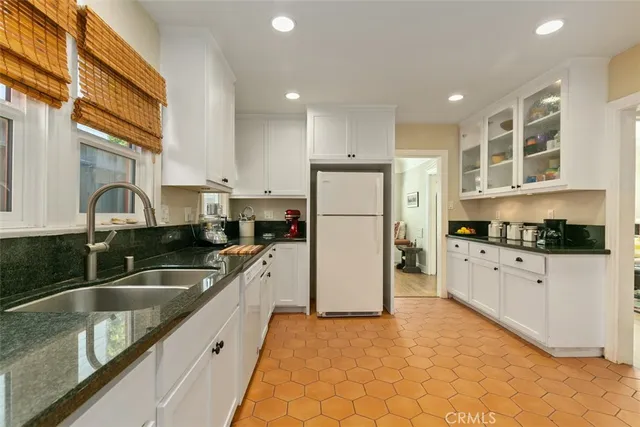 a kitchen with a refrigerator a sink and cabinets