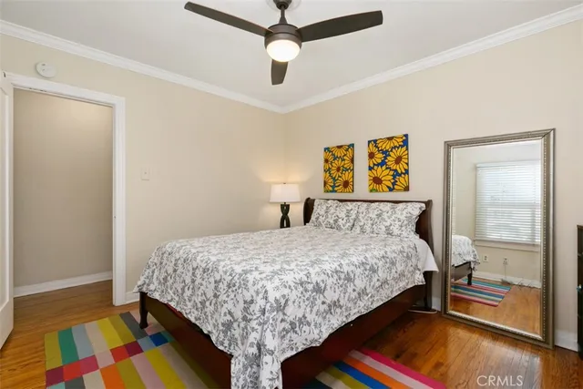 a bedroom with a bed and a dresser next to a window