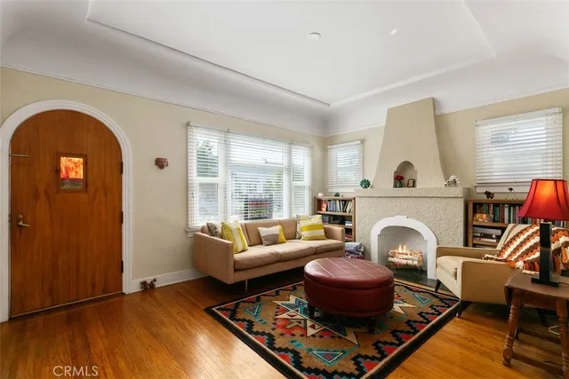 a living room with furniture a fireplace and potted plants