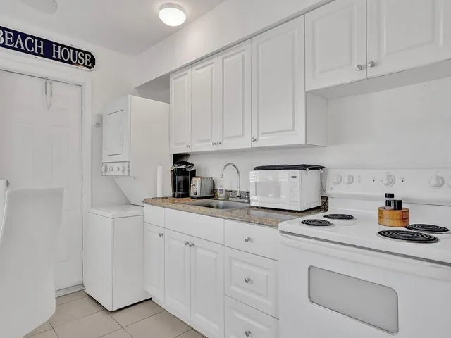 a kitchen with white cabinets and sink