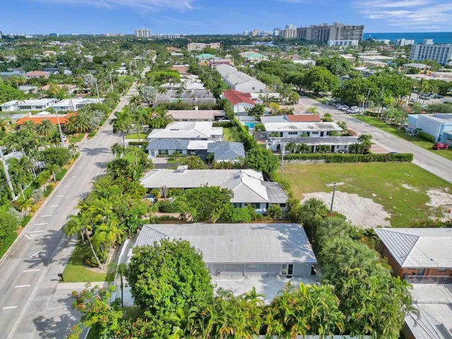 an aerial view of a city with lots of residential buildings ocean and mountain view in back