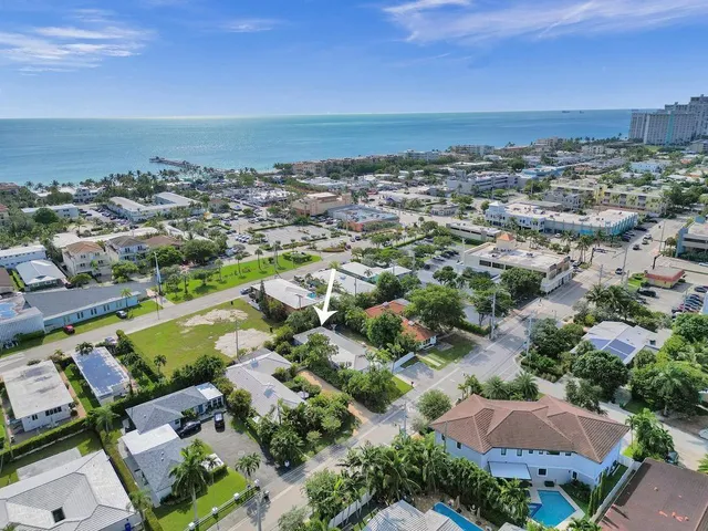 an aerial view of a city with lots of residential buildings and mountain view in back