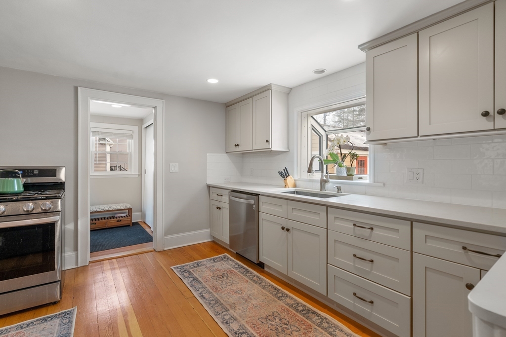 21 Summer Street Sudbury, MA 01776 - Photo 7 of 24 a kitchen with granite countertop white cabinets and stainless steel appliances