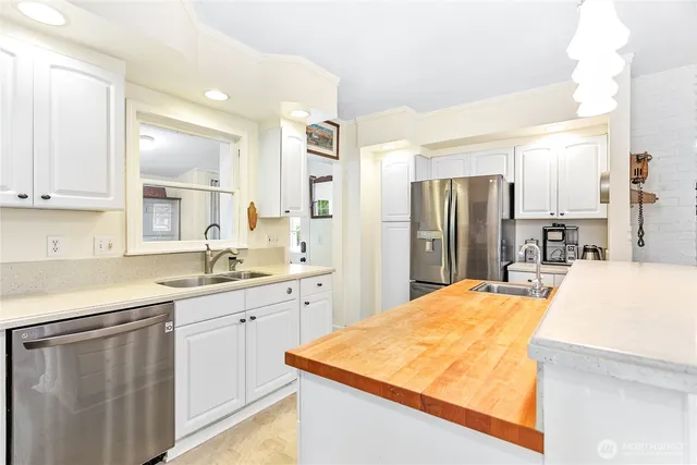 a kitchen with stainless steel appliances granite countertop a refrigerator sink and stove