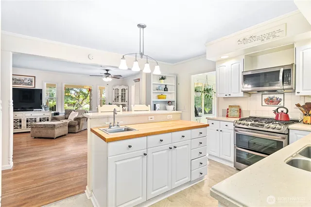 a kitchen with granite countertop a sink stove and cabinets