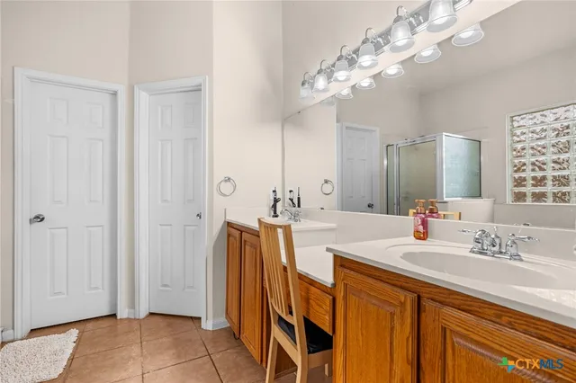 a spacious bathroom with a double vanity sink a mirror and a shower