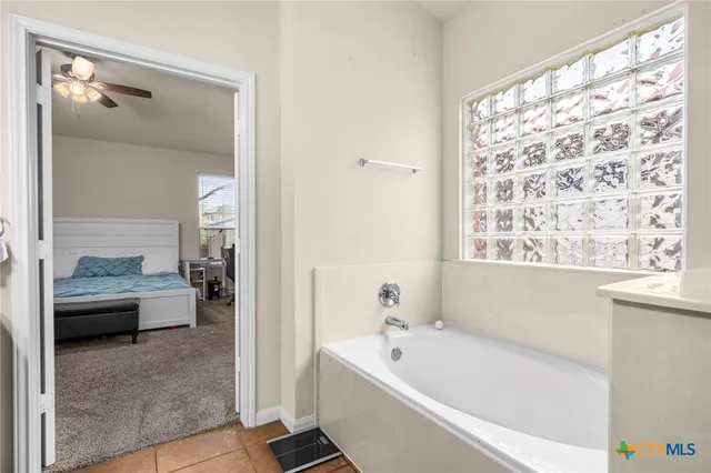 a en suite spacious bathroom with a tub shower and view of bathroom