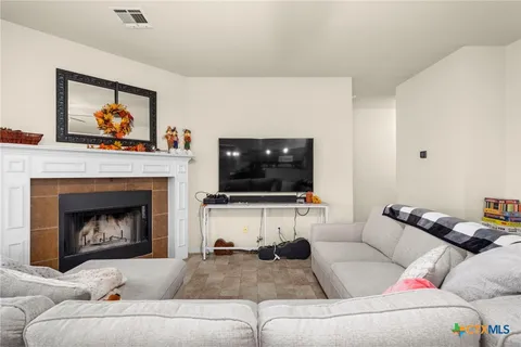 a living room with furniture a flat screen tv and a fireplace