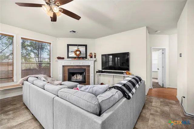 a living room with furniture a flat screen tv and a fireplace