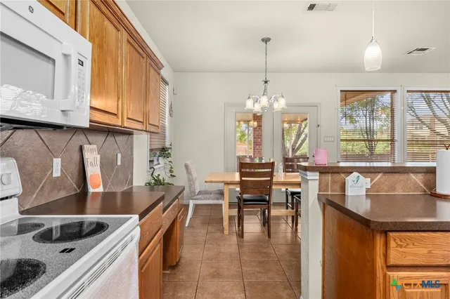 a kitchen with granite countertop a sink a counter top space and living room view