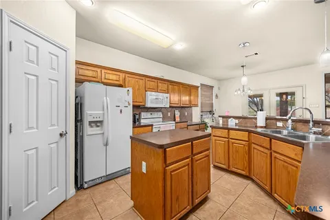 a kitchen with stainless steel appliances granite countertop a refrigerator and a sink