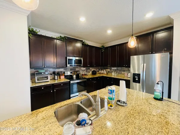 a kitchen with stainless steel appliances kitchen island granite countertop a refrigerator sink and cabinets