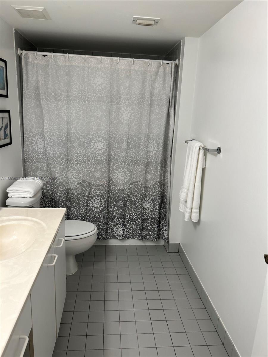 17801 North Bay Road, Unit 203 Sunny Isles Beach, FL 33160 - Photo 13 of 23 a bathroom with a sink a toilet and shower