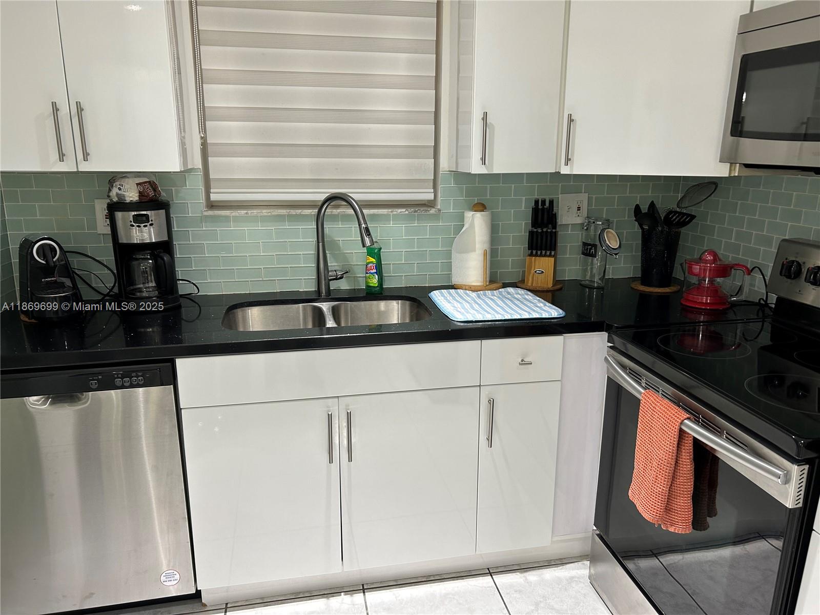 17801 North Bay Road, Unit 203 Sunny Isles Beach, FL 33160 - Photo 20 of 23 a kitchen with stainless steel appliances granite countertop a sink stove and cabinets