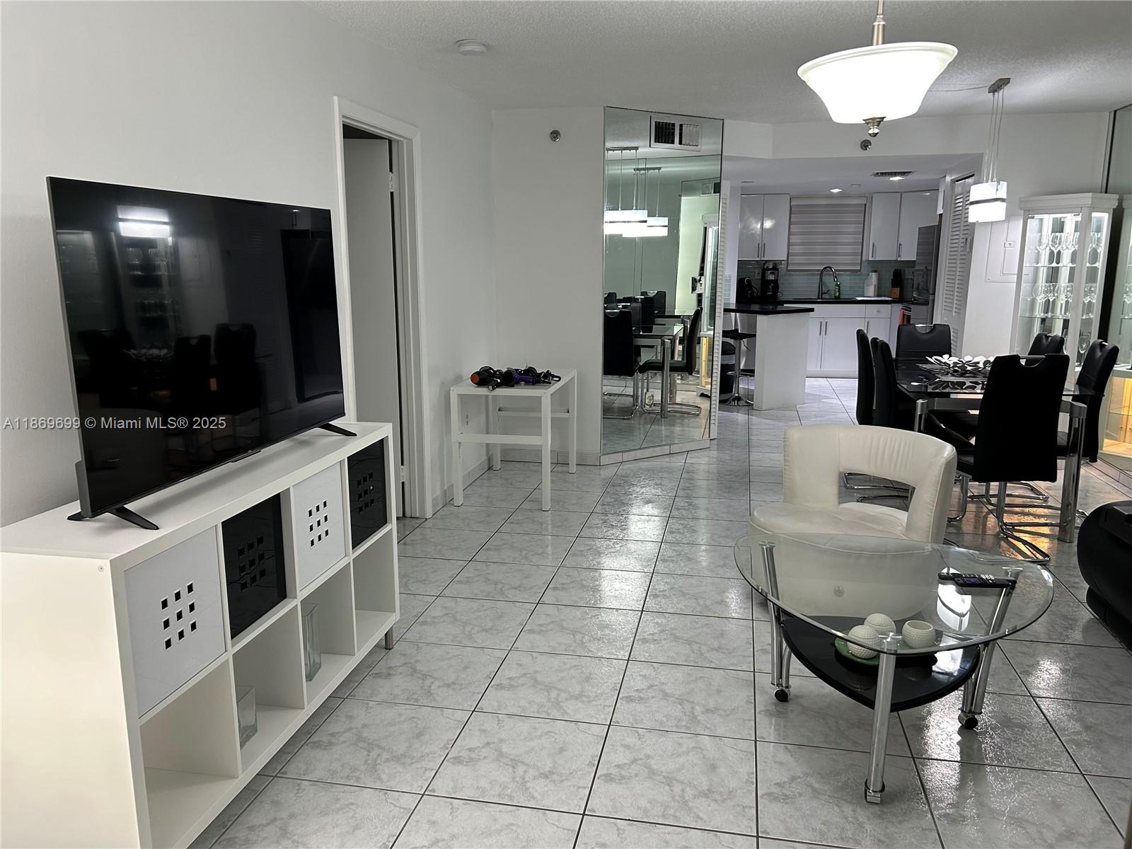 17801 North Bay Road, Unit 203 Sunny Isles Beach, FL 33160 - Photo 21 of 23 a living room with furniture and a flat screen tv