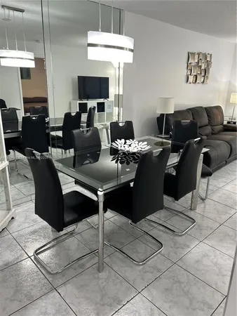 a living room with furniture a flat screen tv and kitchen view