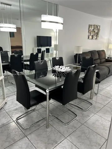 a living room with furniture a flat screen tv and kitchen view