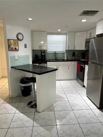 a kitchen with stainless steel appliances kitchen island granite countertop a sink and cabinets